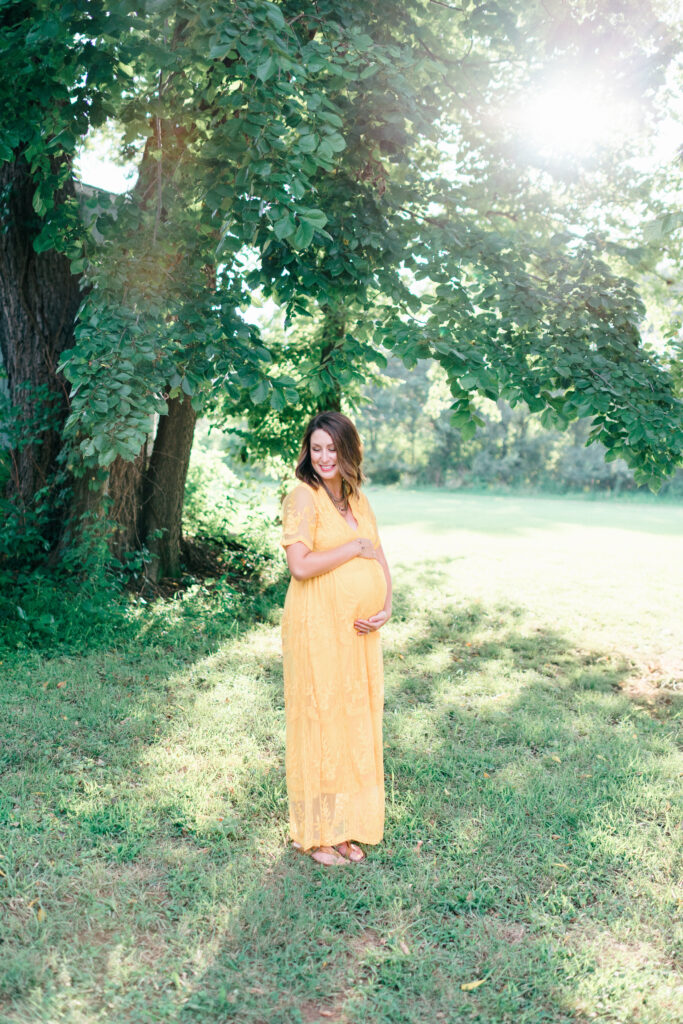 Bentonville maternity captures couple walking, mother has hand on her pregnant belly. 