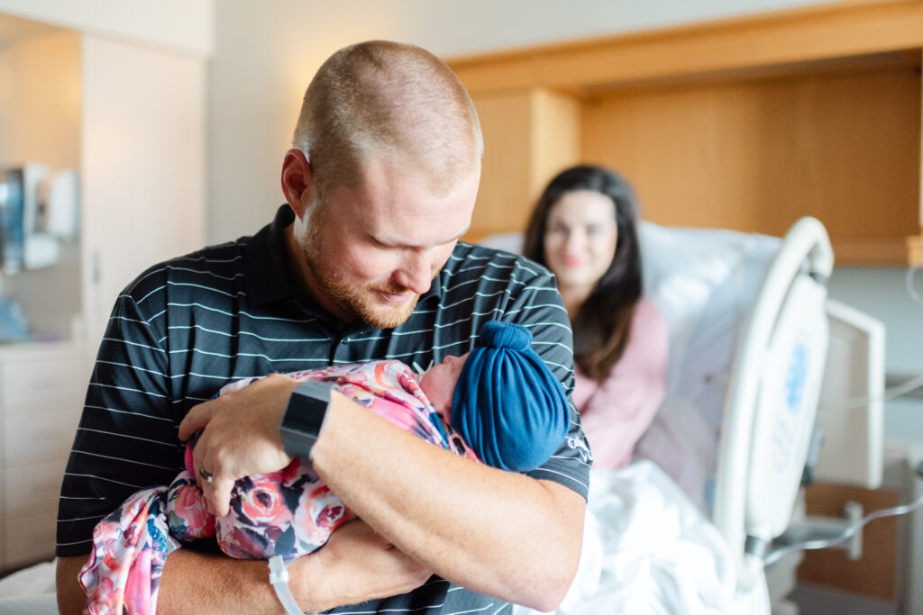 Father holding his newborn daughter close in a serene hospital room at Northwest Medical Center Bentonville