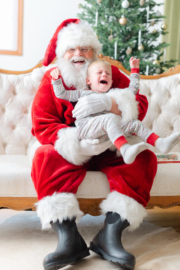 Pictures with Santa: a boy sitting on Santa's lap and crying.