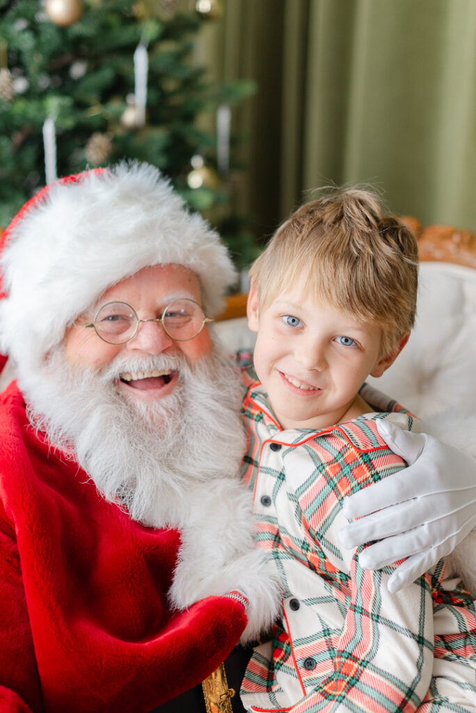 Pictures with Santa: a boy sitting on Santa's lap and smiling.