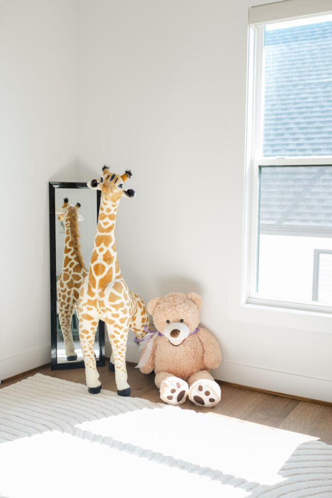 Natural light streams into the nursery as a newborn photographer photographs the decor.