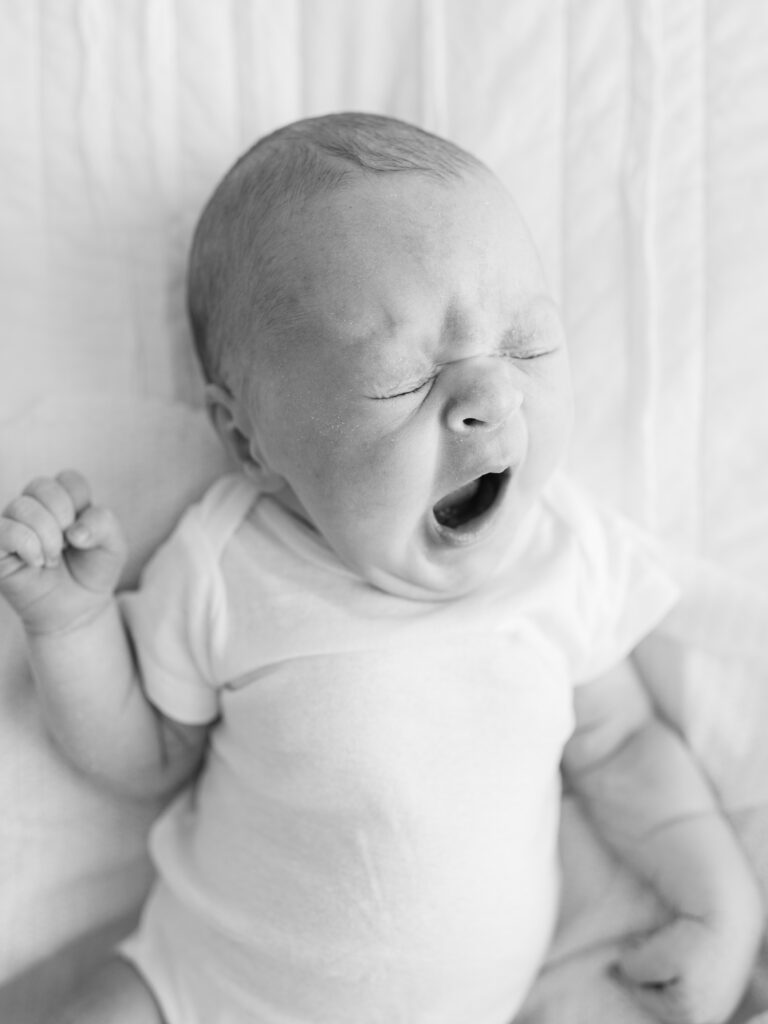 Newborn baby mid-yawn, captured using Burst Mode on a phone camera for candid everyday photos