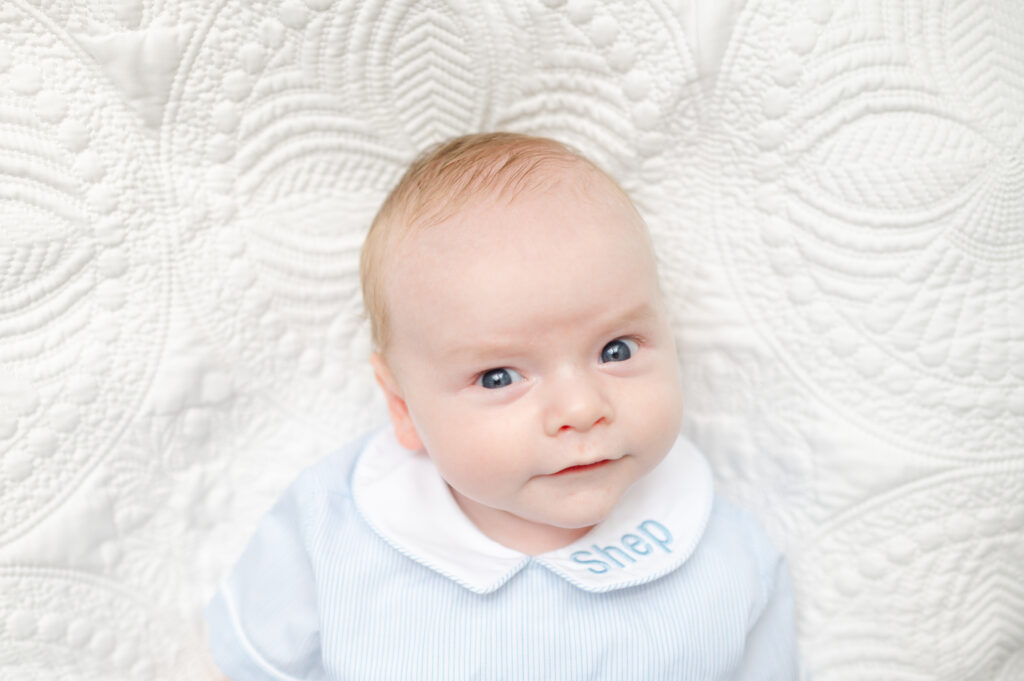 Eye-level close-up of a newborn baby’s face with eyes open, showing flattering angle for everyday baby photography.