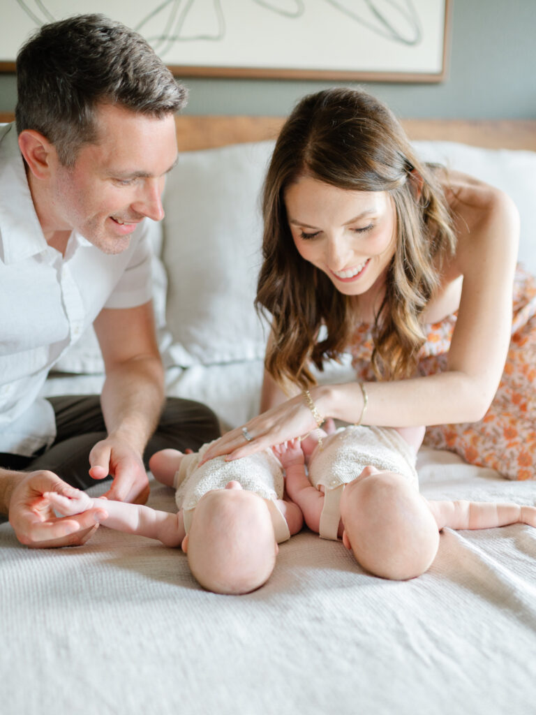 lifestyle newborn photography with twin girls and their parents in their bedroom