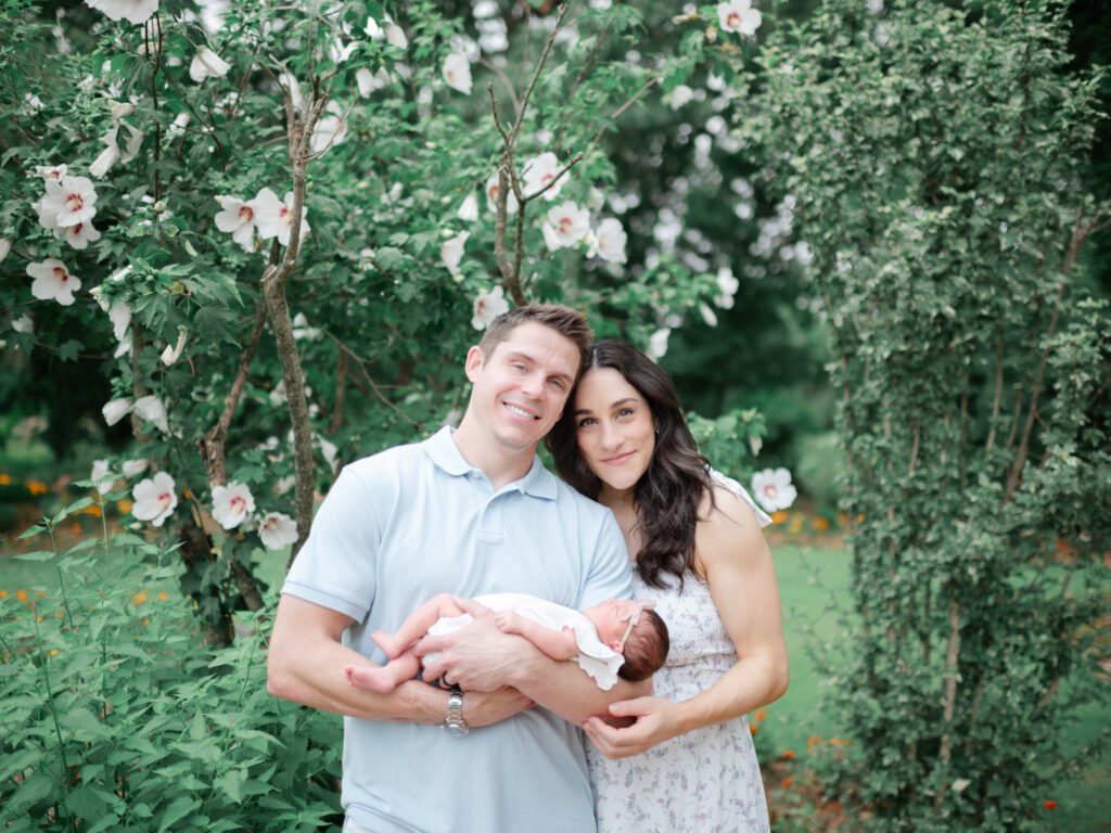 Family portrait of Jordyn, Chris, and baby Gigi during an outdoor newborn session captured by a Northwest Arkansas newborn photographer.