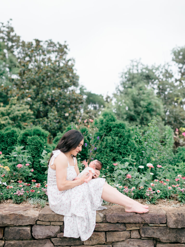 Baby girl Gigi in a floral garden setting during her outdoor newborn session with Jordyn Wieber Brooks, photographed in Fayetteville by a Northwest Arkansas newborn photographer.